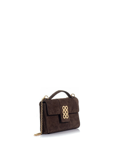 Side view of the KOORELOO Basset Envelope in dark brown suede with structured rectangular silhouette, top handle, signature gold-tone six-circle emblem and chain strap