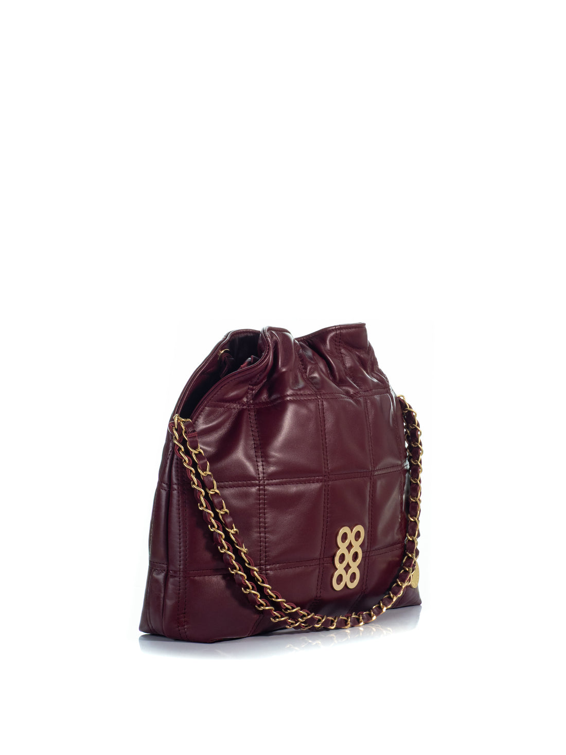 Side view of the KOORELOO Milano Shopper in burgundy leather with geometric stitching, gathered top, signature gold-tone emblem and leather-interwoven chain strap